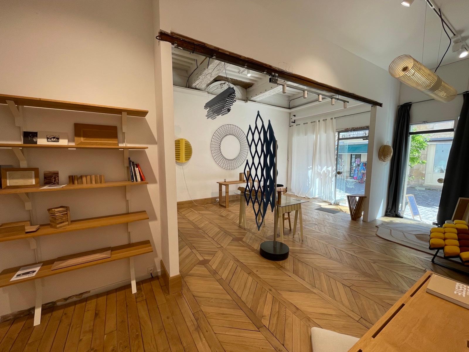 Interior of the Atelier Variation in Semur-en-Auxois — one-of-a-kind pieces, textile creations and wooden objects displayed under an old timber frame