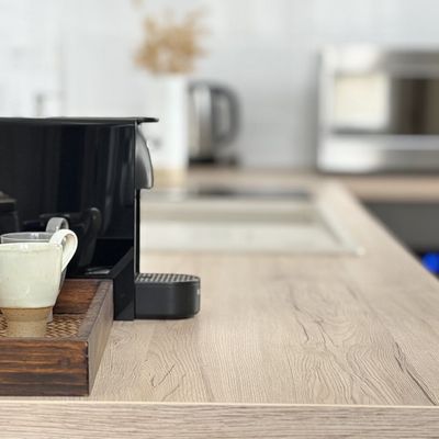 Nespresso coffee machine and an artisanal cup on a rattan tray