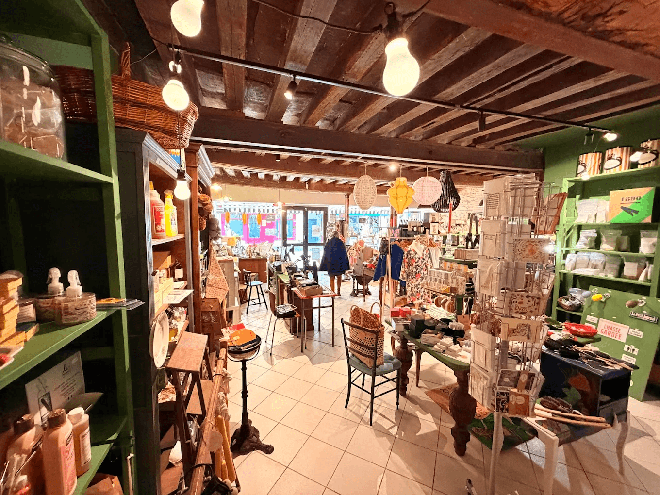 Interior of La Droguerie Buffon in Semur-en-Auxois — concept store and exhibition space, tall green shelves and old beams
