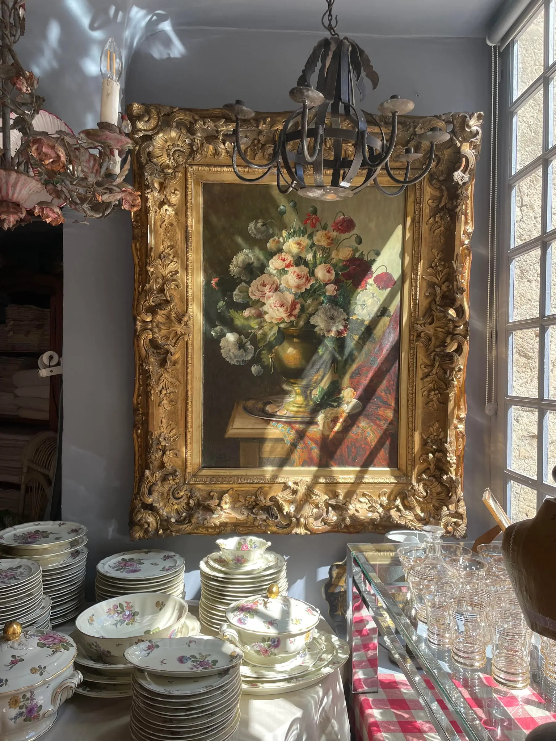 Antique painting in its gilded frame, old porcelain and glassware at Antiquaire porte de Semur, rue de la Liberté in Semur-en-Auxois
