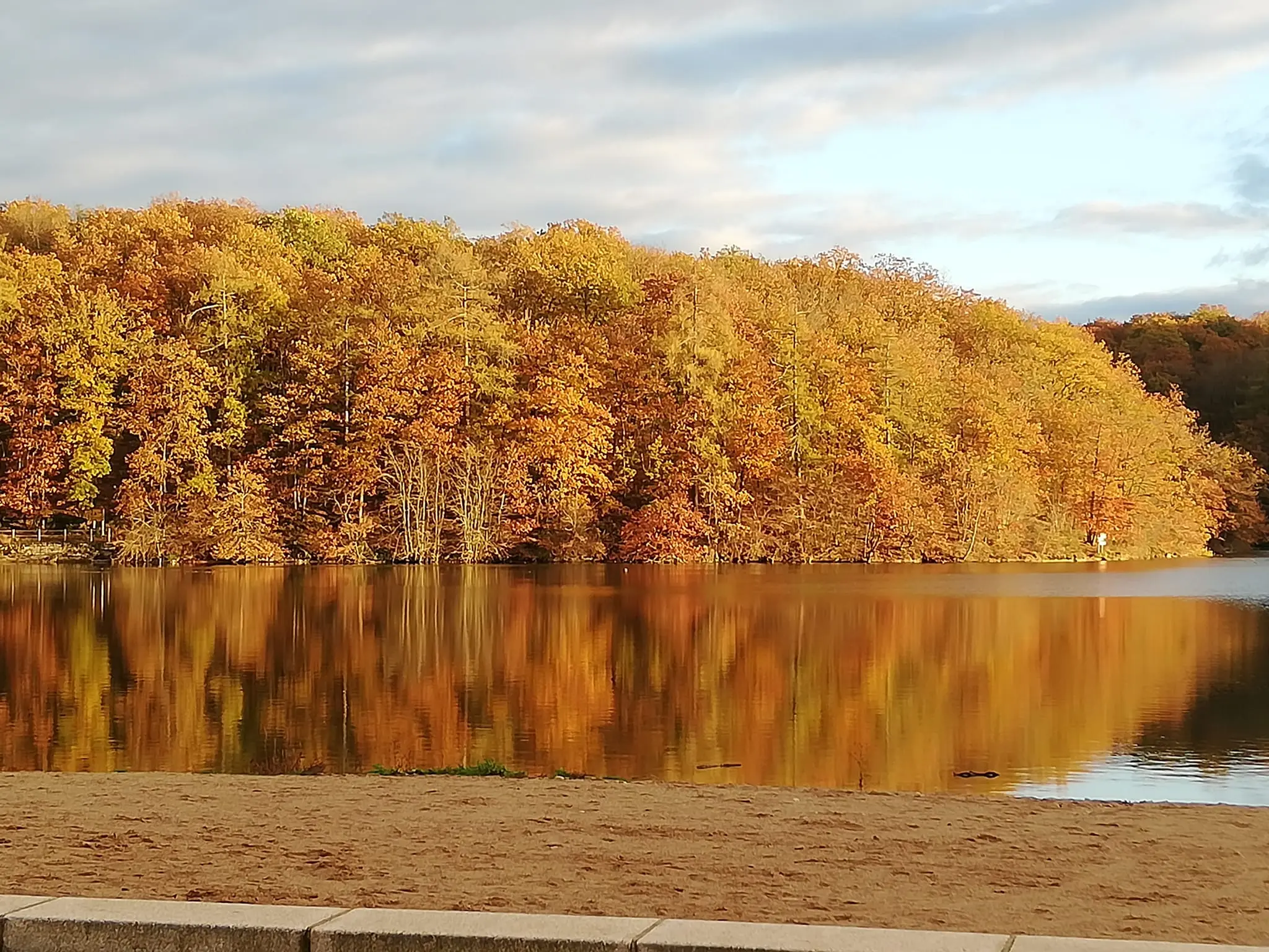 View of the Lac de Pont, a reservoir fringed by the wooded hills of the Auxois