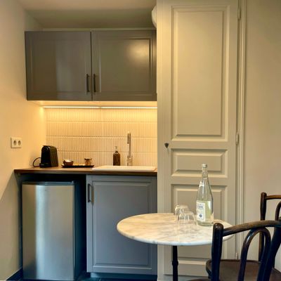 Fitted kitchenette with a marble bistro table and coffee machine