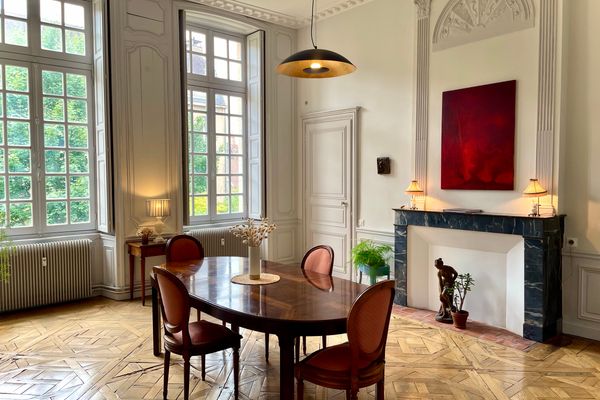 Dining room with grand mansion proportions: Versailles parquet, marble fireplace and tall windows onto the garden