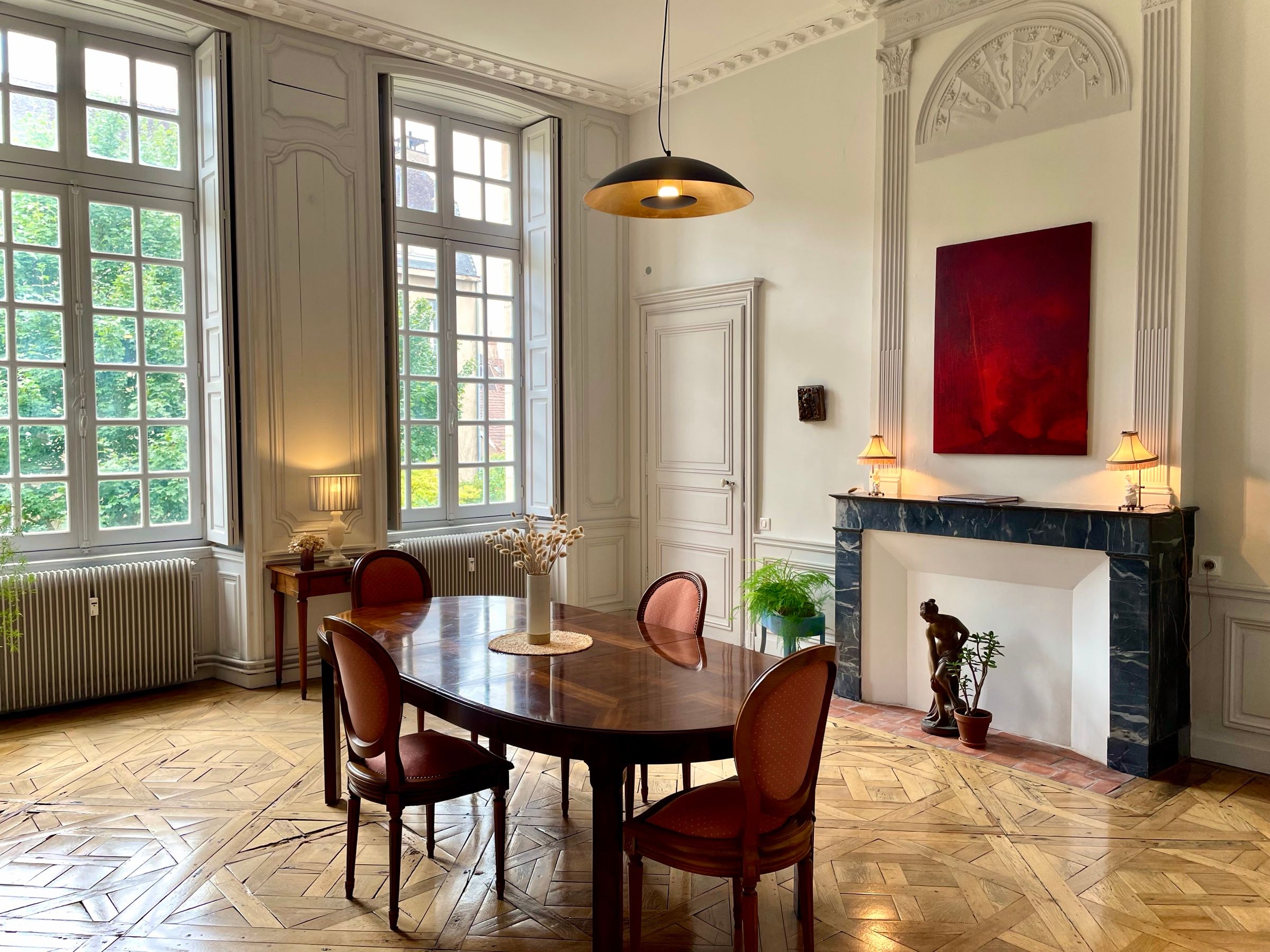 Dining room of the Suite Côté Jardin: Versailles parquet, marble fireplace, tall windows onto the garden and 18th-century panelling