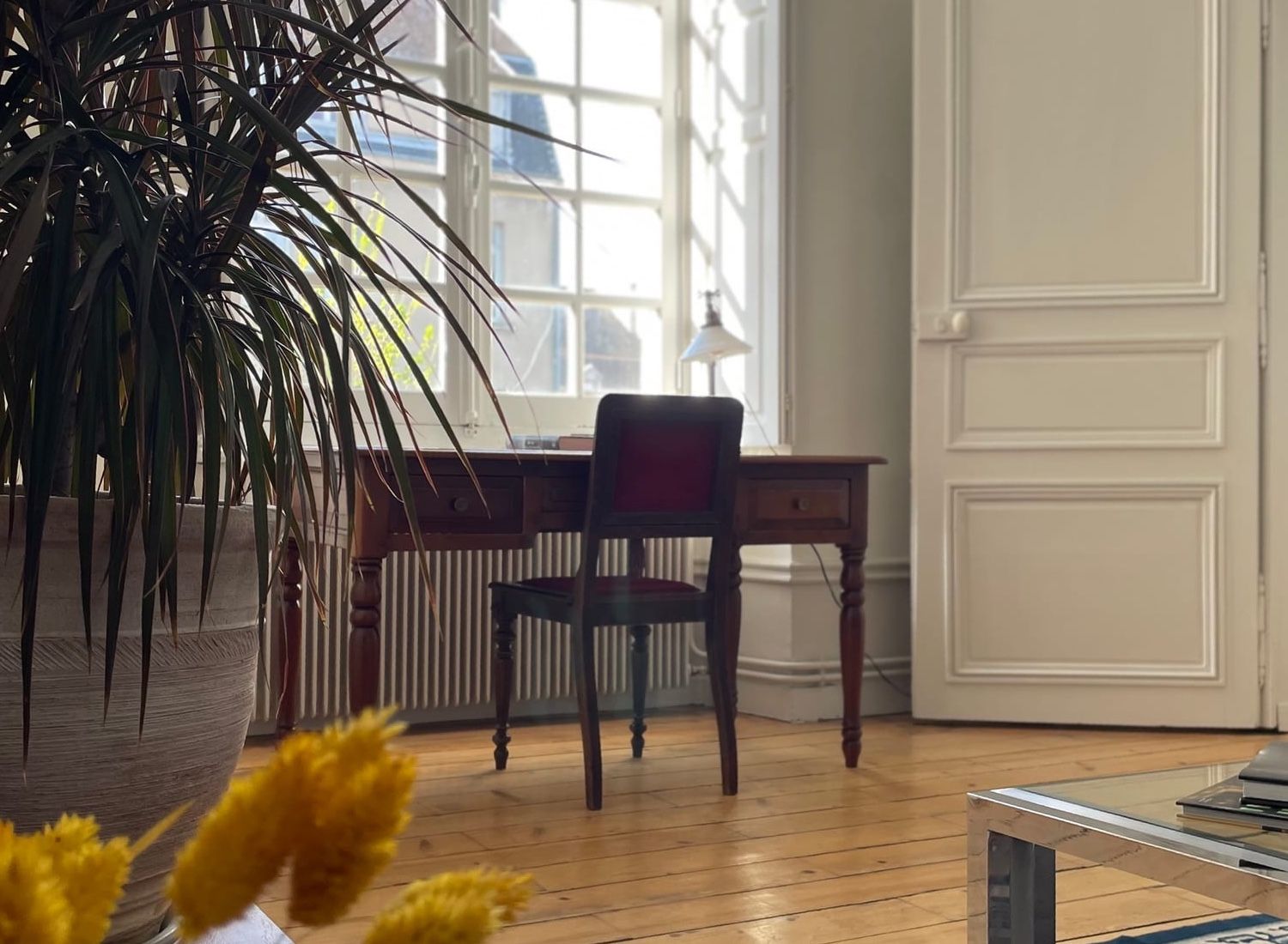Period writing desk facing the window of the Suite Côté Jardin, Persian rug and soft light